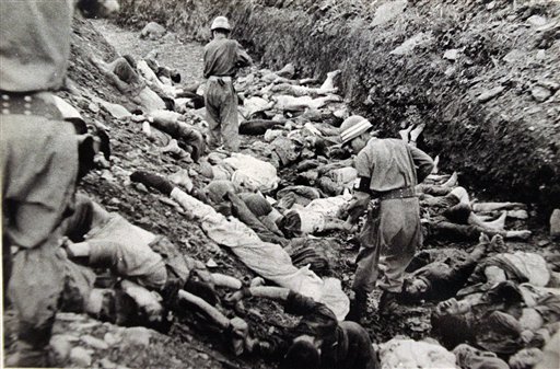 Soldats enmig d'una fossa comuna amb presos polítics acusats de comunistes, massacrats en Daejeon amb la complaença dels EUA, juliol de 1950